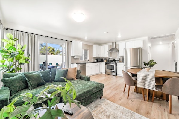 A modern apartment with a living area, kitchen, and dining space.