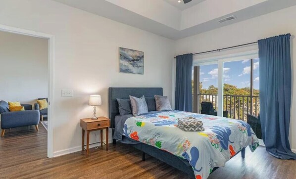 Ein Schlafzimmer mit Bett, Nachttisch und Blick ins Freie.