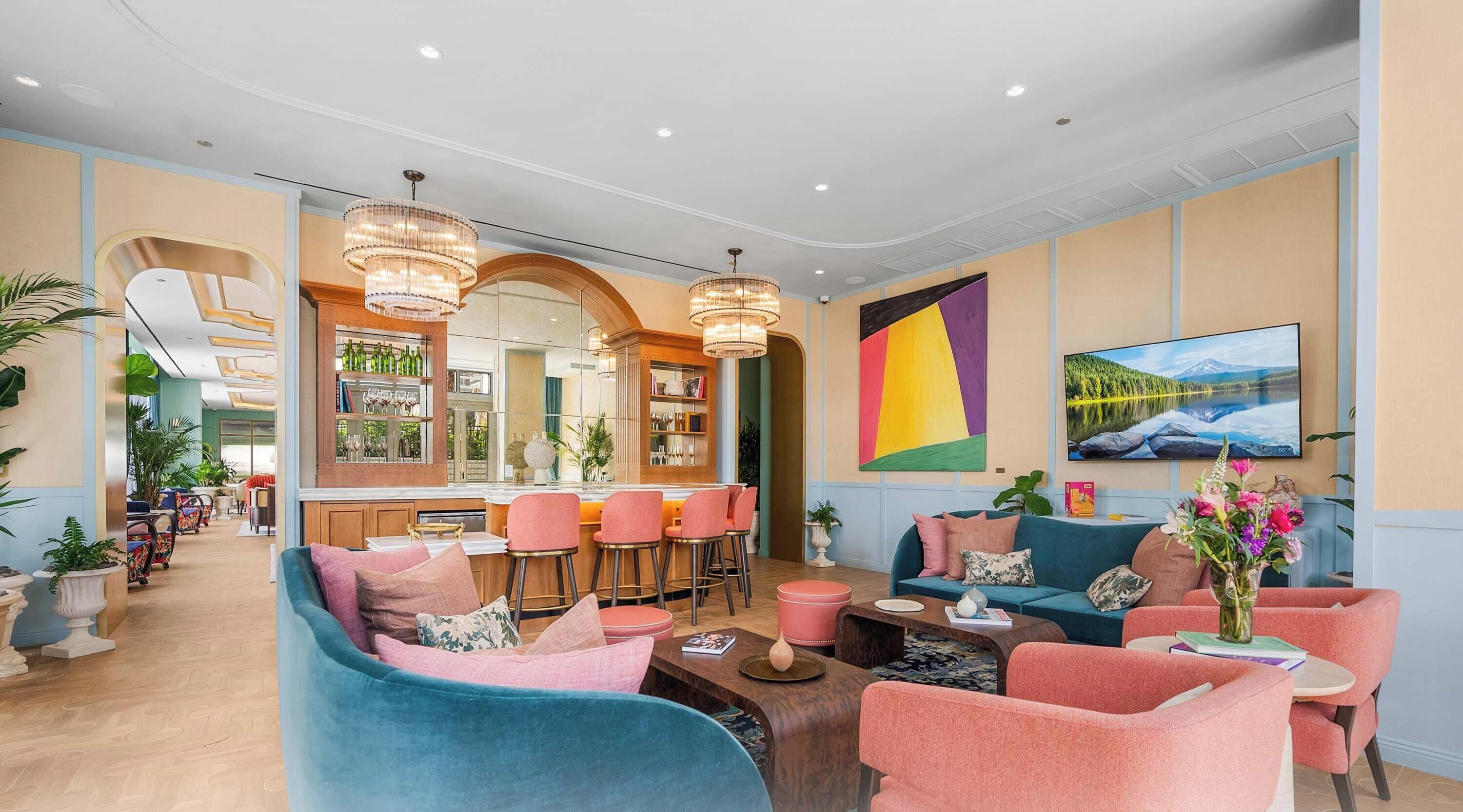 A hotel lobby with a bar area, seating arrangements, and a large wall painting.