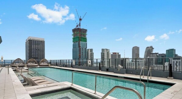 Ein Pool auf dem Dach mit Stadtansicht im Hintergrund.