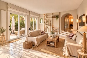 Ein geräumiges Wohnzimmer mit einer Sofagarnitur, einem Couchtisch und einem Bücherregal.