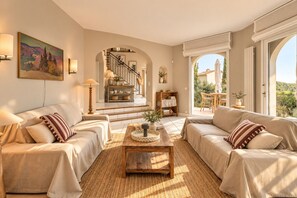 A spacious living room with two sofas, a coffee table, and a staircase leading to an outdoor area. - Villa Vany - Provence & View (Éguilles)