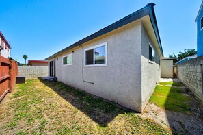 A single-story house with a small front yard, a wooden fence, and a clear sky. - South Bay Hideaway - 3BR/2BA Near LAX, Beaches & SoFi - Monthly Stays (Lawndale)
