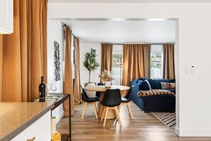 Een moderne woonruimte met een eethoek, een bank en een plant.