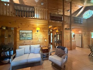 A wooden interior with a sofa, a small table, and a lamp.