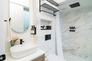 A modern bathroom with a large white sink, a mirror, a towel rack, and a shower area with a white shower curtain. - Mini Loft w/ Cibeles Fountain View - Balcony & AC (Ciudad de México)