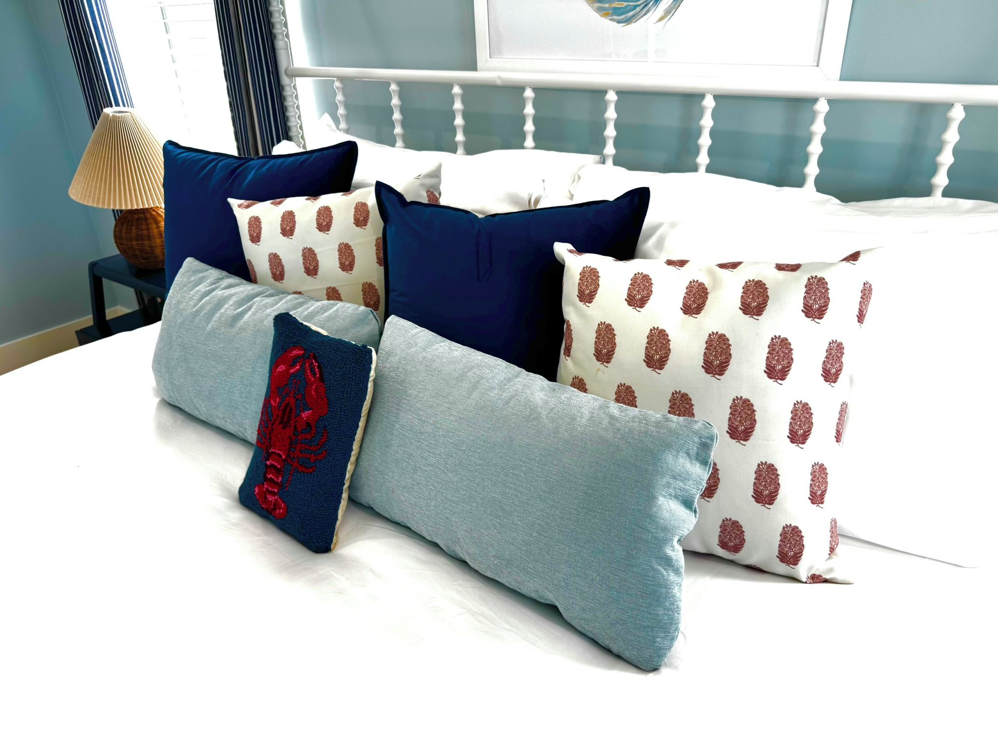 Una cama con muchos cojines de diversos diseños y colores.