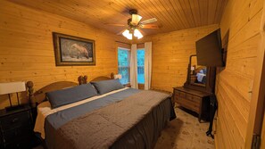 A wooden room with a bed, a dresser, a television, and a ceiling fan. - Buffalo Valley Retreat-Secluded 2-bedroom cabin 8 minutes from Jasper (Jasper)