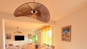 Una cocina moderna con isla de madera, armarios blancos y una lámpara colgante.