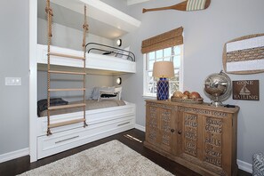 A bunk bed with a rope ladder, a wooden cabinet with sports equipment, and a globe on a dresser. - Gorgeous 3-bedroom home in beautiful CDM with AC and backyard (Newport Beach)