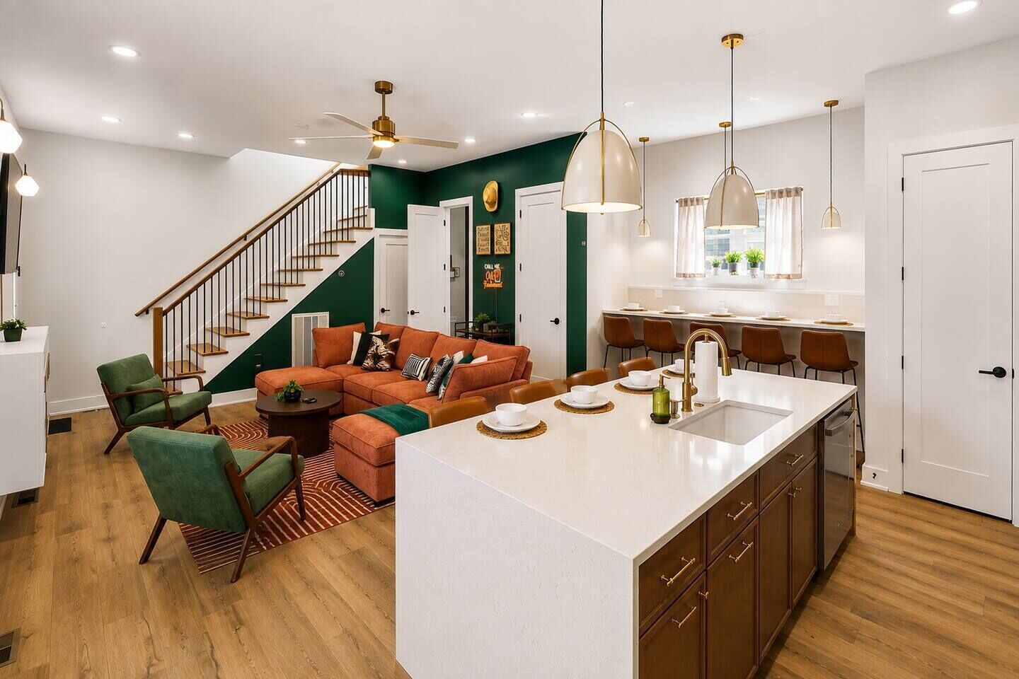 A modern living room with a sofa, chairs, and a dining area with a kitchen island.
