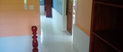 A hallway with a wooden door, a white wall, and a blue wall.