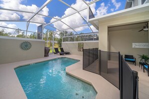 Une piscine entourée de parois en verre, des chaises longues et un panneau indiquant « Bienvenue ».