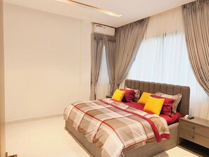 A bedroom with a bed, bedside table, and an air conditioning unit. - 3 bedroom all ensuite split level luxury penthouse with skyline views over Abuja (Abuja)