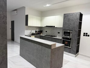 Een moderne keuken met een centraal eiland, inbouwapparatuur en een minimalistisch design.
