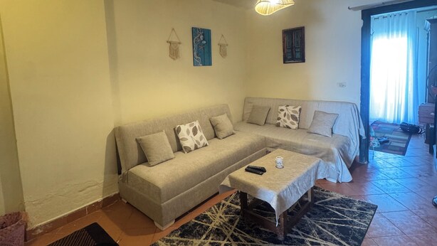 A living room with a sofa, coffee table, and a hanging light fixture. - Perfect chalet for rent North coast porto golf marina (Marsa Matrouh Governorate)