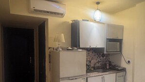 A compact kitchen with a refrigerator, microwave, and a small countertop. - Perfect chalet for rent North coast porto golf marina (Marsa Matrouh Governorate)