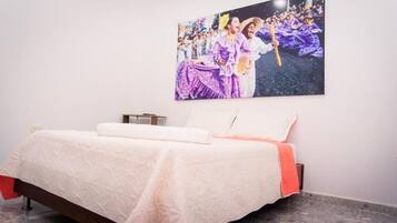 Una habitación de hotel con una cama, una mesita de noche y un cuadro colgado en la pared.
