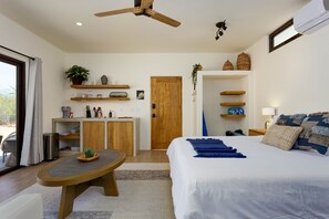 Une chambre moderne avec un grand lit, un bureau et un coin repas.