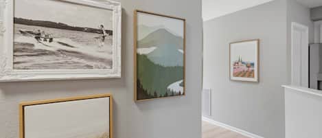 A hallway with three framed artworks on the wall.