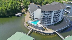 A multi-story hotel with a pool, located by a body of water. - Main-channel Views, Heated Pool, Boat Slips & Huge Deck (Osage Beach)