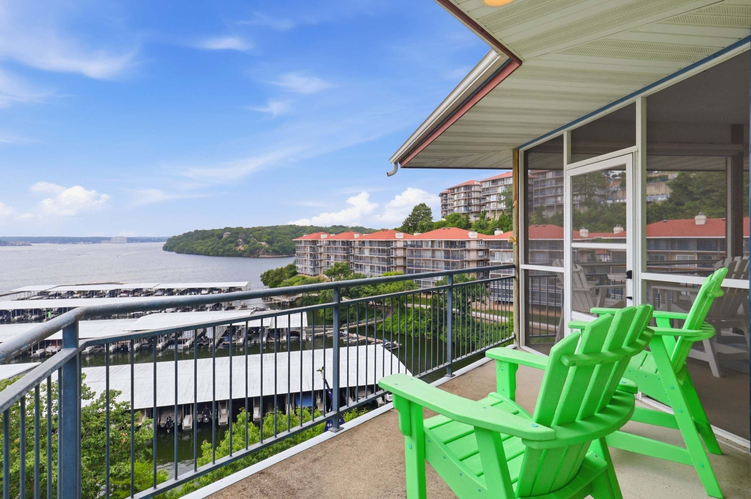A balcony with a view of a marina and buildings across the water.