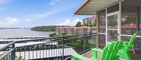 A balcony with a view of a marina and buildings across the water.