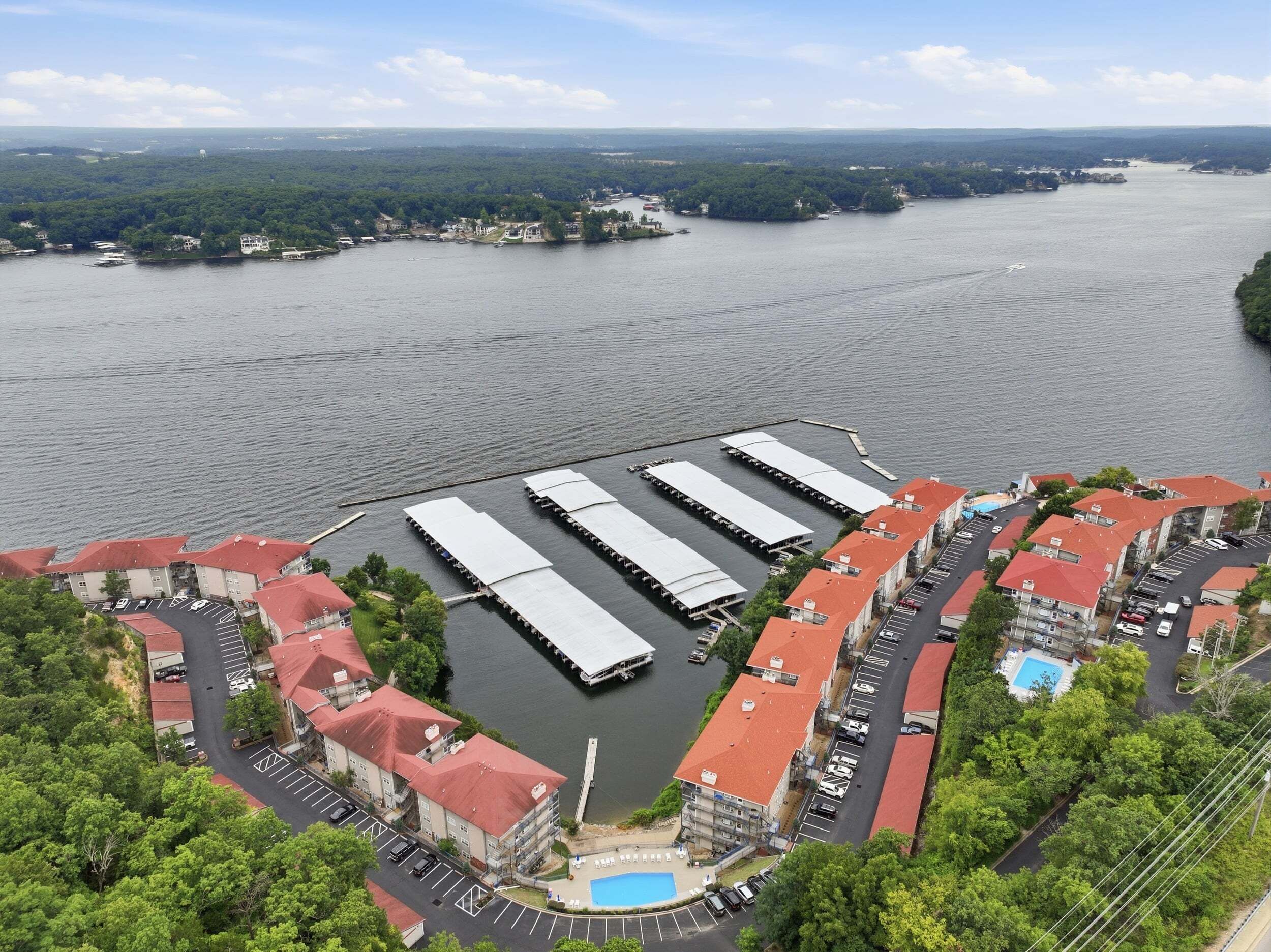 A waterfront hotel with multiple buildings, a dock, and a swimming pool.