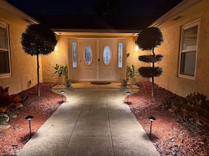 A house with a double door, two potted plants, and a pathway leading to the entrance. - Welcome to your Private Lake Worth Oasis getaway! (Lake Worth)