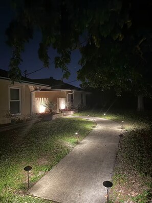 A residential property at night with a well-lit driveway and a house with a porch. - Welcome to your Private Lake Worth Oasis getaway! (Lake Worth)