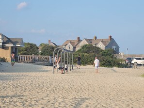 A sandy beach with a playground structure, houses in the background, and a wooden fence. - Walk to the beach from this lovely 6-bedroom house in Yarmouth (Yarmouth)