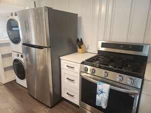 Eine Küche mit einem Edelstahl-Kühlschrank, einem eingebauten Backofen und einem Gasherd.