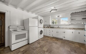 A kitchen with white appliances, including a stove, oven, and washing machine, and a window with a view. - Walk to the beach from this lovely 6-bedroom house in Yarmouth (Yarmouth)