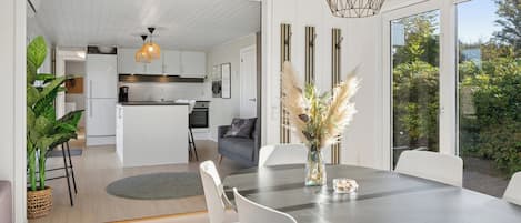 Una cocina moderna con armarios blancos, una isla central e iluminación colgante.