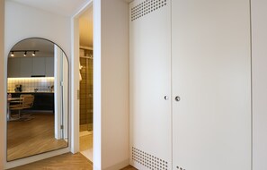 En modern inredning med ett köksområde, ett matbord med stolar och en garderob med en unik, perforerad design.