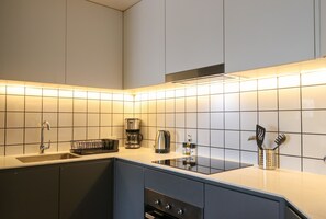 A modern kitchen with a built-in stove, a coffee maker, and a kettle on the countertop. - w* | Upscale 2BR with Balcony in Prime Miraflores (Miraflores)