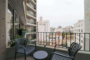 A balcony with two chairs and a small table, overlooking a residential area with multiple buildings. - w* | Upscale 2BR with Balcony in Prime Miraflores (Miraflores)
