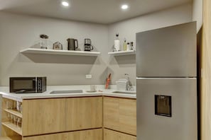 A modern kitchen with a built-in microwave, a stainless steel refrigerator, and wooden cabinetry. - w* | Refined Loft w/ Balcony in Usaquen (Bogotá)