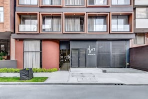 A modern building with a flat facade, large windows, and a visible entrance. - w* | Refined Loft w/ Balcony in Usaquen (Bogotá)