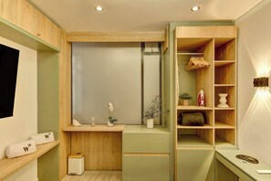 Een moderne badkamer met houten kastjes, een wastafel met spiegel en een plank met handdoeken.