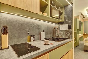 Eine moderne Küche mit integriertem Induktionskochfeld, einer Edelstahl-Spüle und einem Holzkorpus.