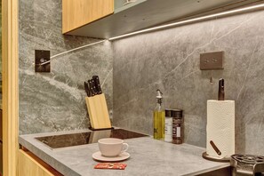A modern kitchen with a marble backsplash, a knife block, a coffee cup, and a gas stove. - w* | Charming & Cozy 3BR in the Heart of Zona T (Bogotá)