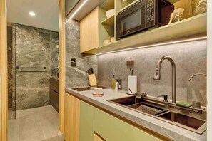 A modern kitchen with a built-in microwave, sink, and a marble backsplash. - w* | Charming & Cozy 3BR in the Heart of Zona T (Bogotá)