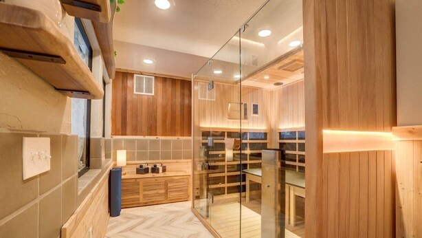 Ein modernes Badezimmer mit Holzvertäfelung, einer Glasdusche und einem Fischgrätparkett.