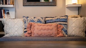 Ein Sofa mit gemusterten Kissen und einem Spiegel darüber.