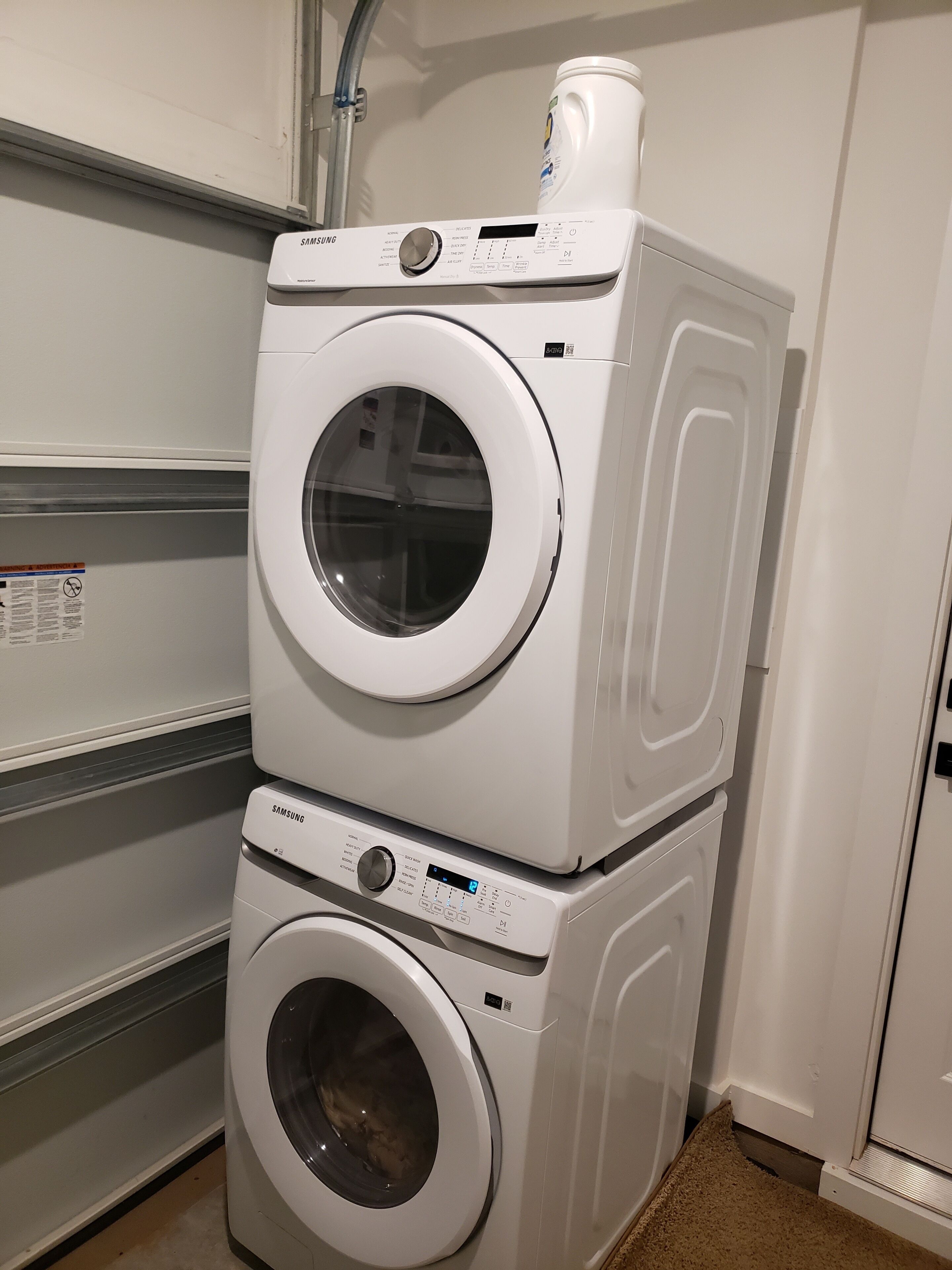 A stacked washer and dryer unit in a laundry room.