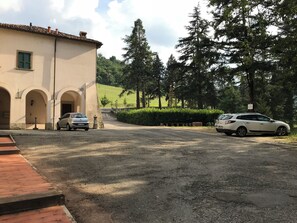 Ein Gebäude mit Rundbogenportalen und einem Schotterweg.