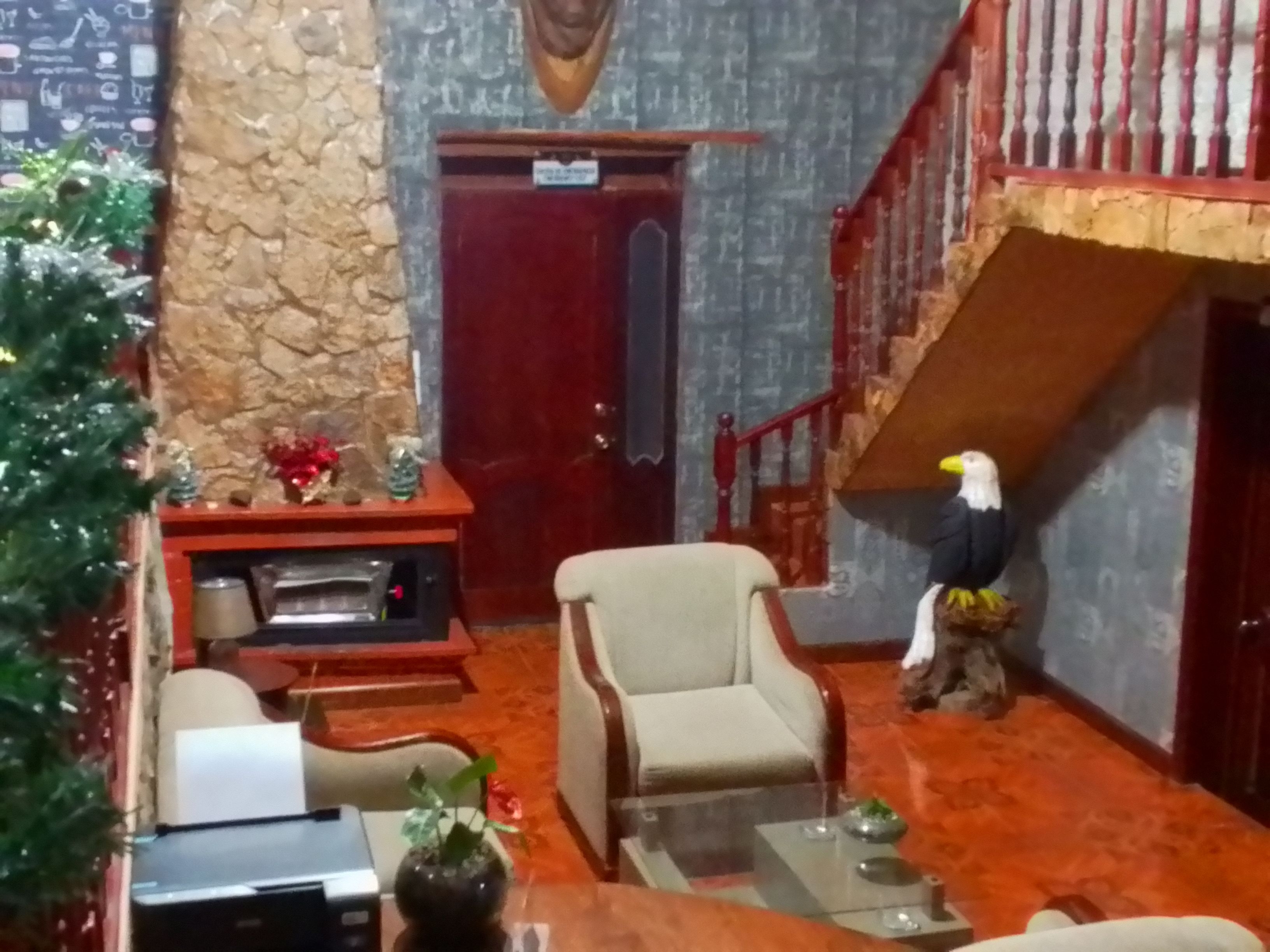 Une pièce avec une cheminée, un canapé, une table basse et une statue d’oiseau décorative.