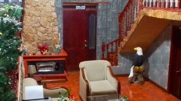 Une pièce avec une cheminée, un canapé, une table basse et une statue d’oiseau décorative.