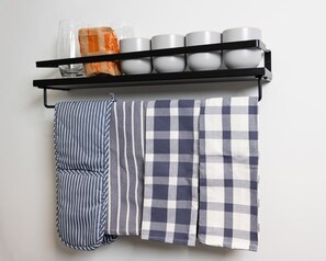 A kitchen shelf with white mugs, a striped towel, and a checkered towel. - Spruce Villa - 3rd Floor King Studio (Philadelphia)